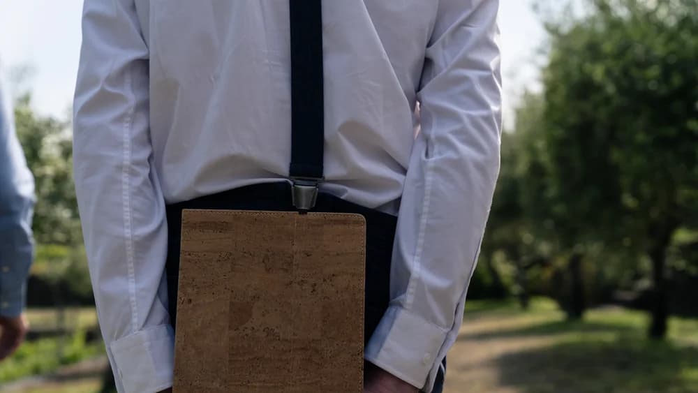 Een medewerker van de zaal draagt een tablet in een kurken hoes.